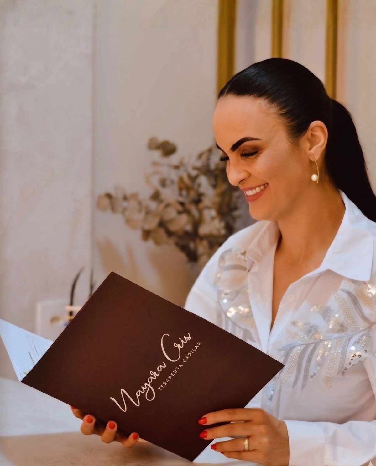 Nayara Cris, terapeuta capilar, durante um atendimento